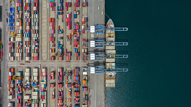 Aerial view cargo ship terminal, Unloading crane of cargo ship terminal, Aerial view industrial port with containers and container ship.