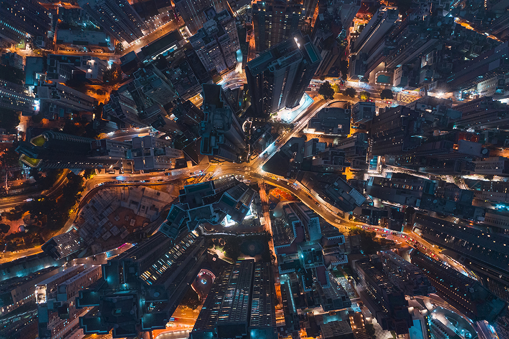 Aerial top view Road and Hong Kong Cityscape at Night for Transportation or Futuristic concept background.